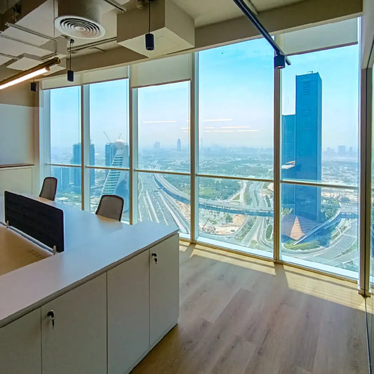 Corner desk setup with floor-to-ceiling windows and panoramic city view