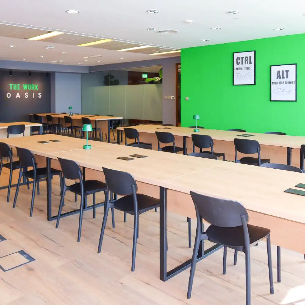 Bright coworking space with modern desks and green desk lamps at The Work Oasis, Abu Dhabi.