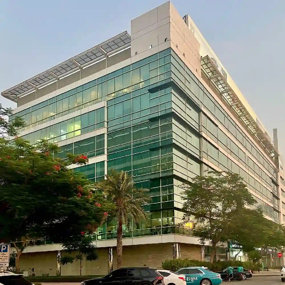 Modern office building with glass facade and surrounding greenery