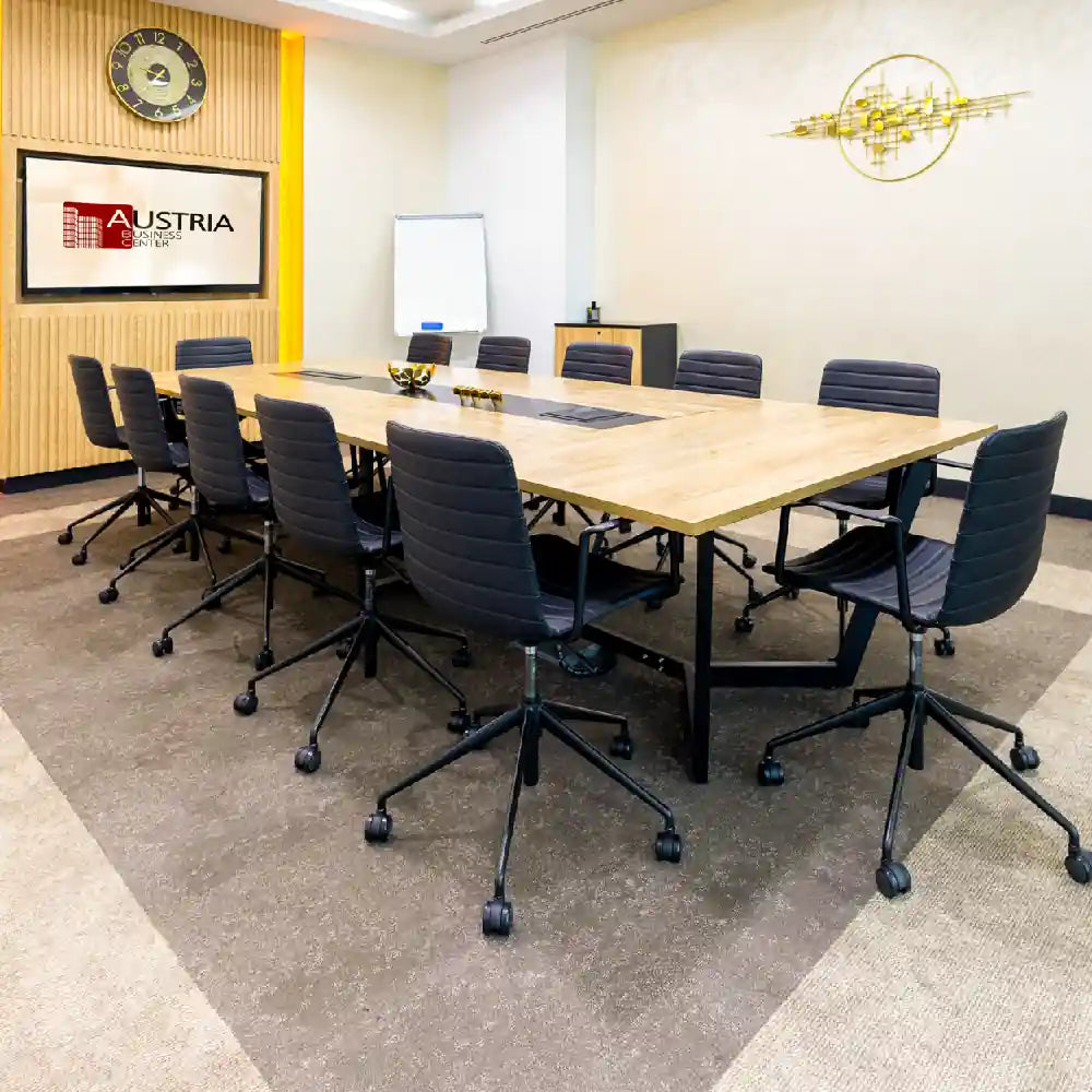 Modern boardroom seating 12 with presentation facilities at Austria Business Center, Al Hudaiba Mall.