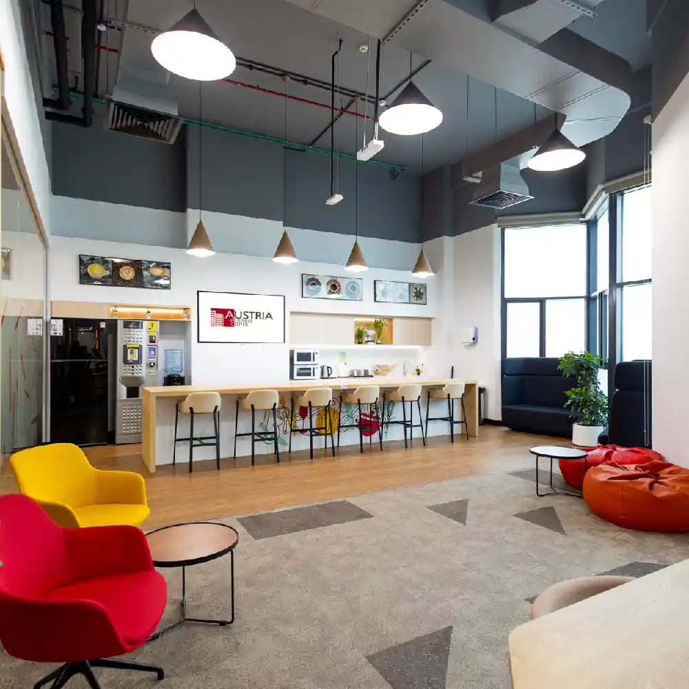 Pantry and coffee bar with high stools and modern appliances at Austria Business Center, Al Hudaiba Mall