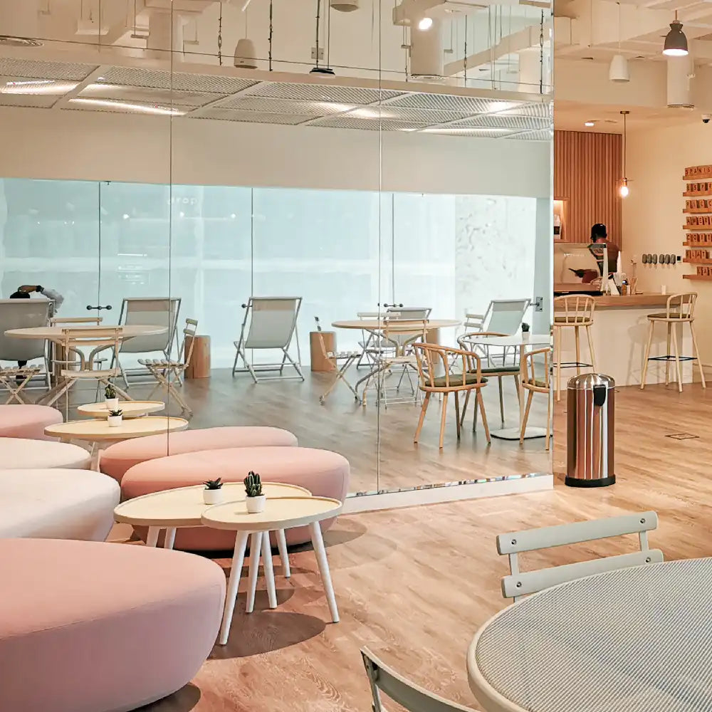 Modern office space with glass walls, chairs, and tables.