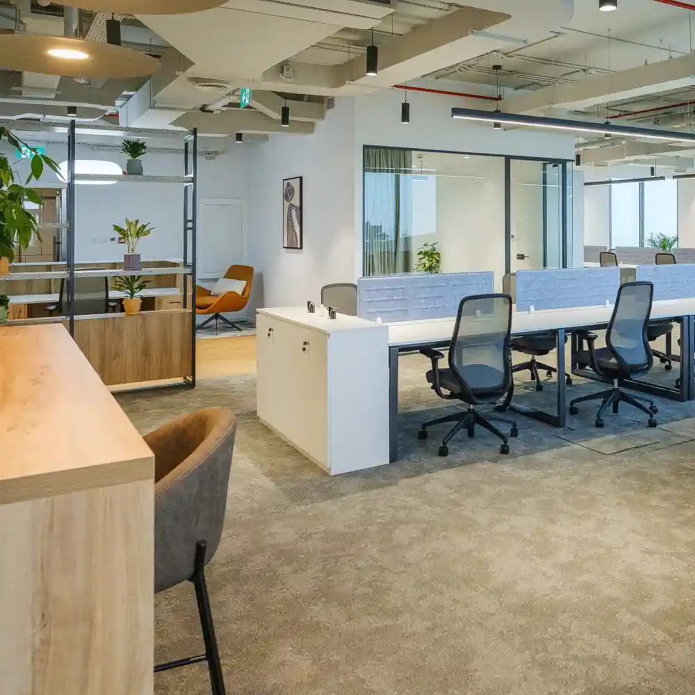 Workstations with hot desk seating and reception area in the background at Rice – Al Salam Tower