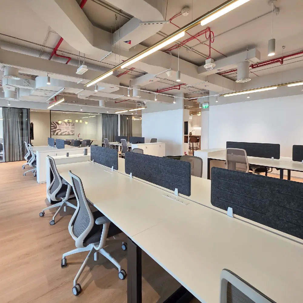 Open collaboration space with central table, soft chairs, and wall art