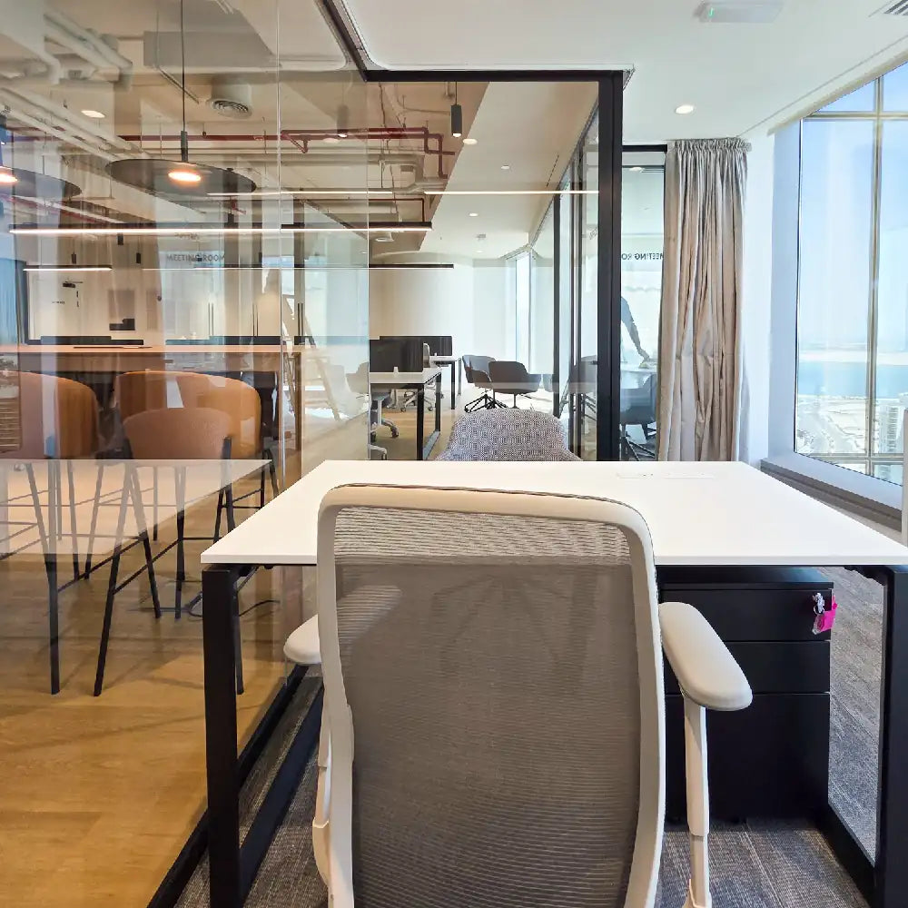 View through glass-partitioned office with multiple workspace zones