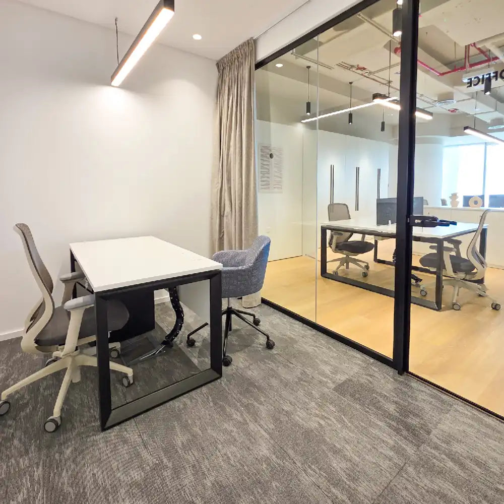 Private 2-person desk zone with soft lighting and minimal decor