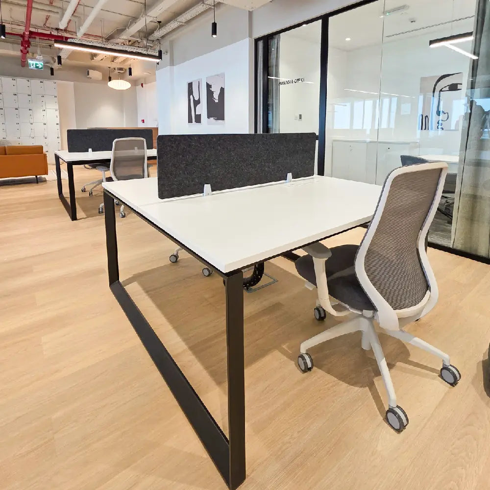 Private desk area beside full-height windows with skyline views