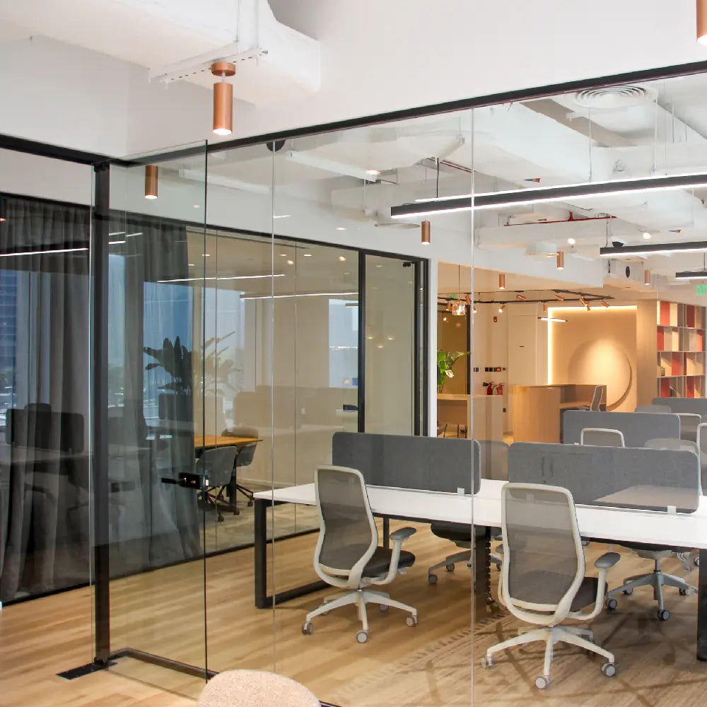 Modern office interior with glass walls and office chairs.