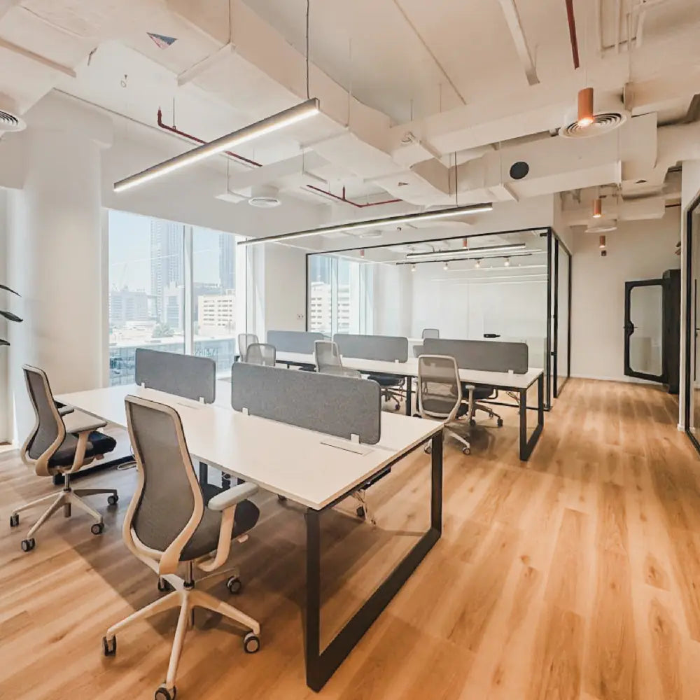 Modern office space with desks and chairs near large windows