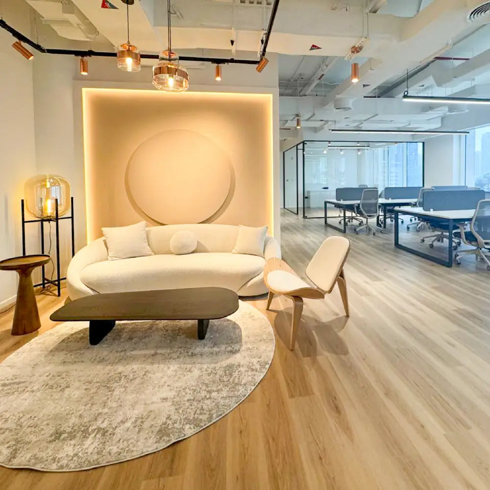 Modern office interior with a white sofa, coffee table, and decorative elements.