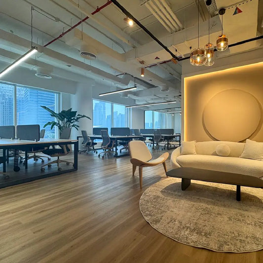 Reception waiting area with modern sofa and open-plan workstations at Space1 Office 6